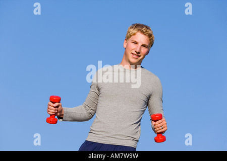 Ein junger Mann, 22 Jahre alt, training mit Hanteln Stockfoto