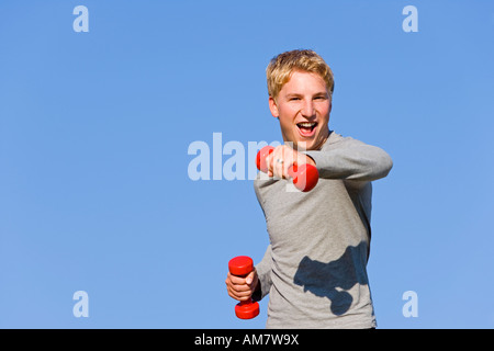 Ein junger Mann, 22 Jahre alt, training mit Hanteln Stockfoto