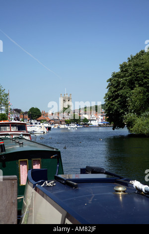 Thameside Blick auf Henley on Thames an heißen, sonnigen Sommertag mit festgemachten Booten im Vordergrund und Kirche im Hintergrund Stockfoto