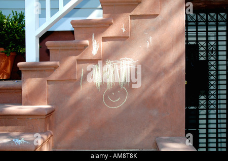 junge Kinder Kreide Zeichnung von einem Smiley auf Wohn Zement Treppe Stockfoto