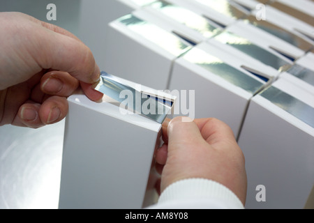 Person, die Kartons im Schutzraum bei pharmazeutischen Unternehmen Stockfoto