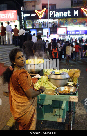 Eine Frau mit einem Handwagen verkauft, Mais und Ananas an der Ecke Kirchgasse und Brigade Road, Bangalore, Indien Stockfoto