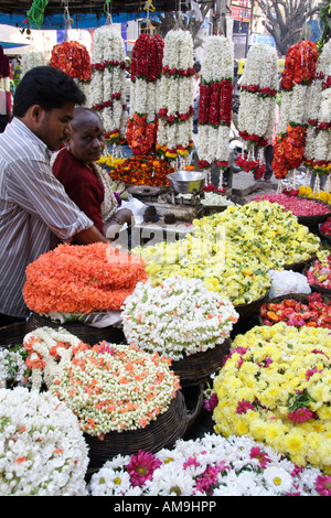 Eine bunte Blume stall auf dem Gandhi-Basar in Bangalore, Indien, mit Körben von kühn farbigen Blumen und Girlanden aufhängen. Stockfoto