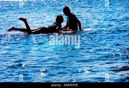 Paar auf Surfbrettern in den Wasser-lächelnd. Stockfoto