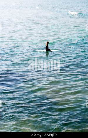 Frau sitzt auf Surfbrett im Wasser. Stockfoto