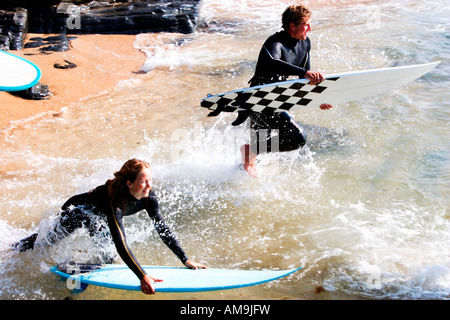 Koppeln Sie mit Surfboards planschen im Wasser lächelnd. Stockfoto