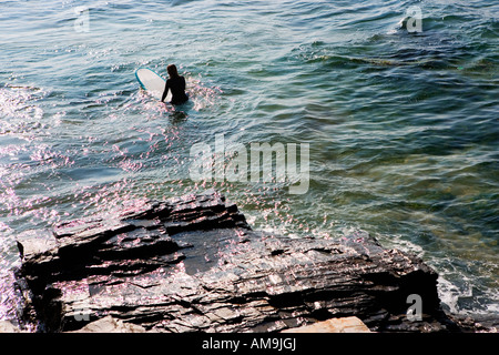 Frau sitzt auf Surfbrett im Wasser. Stockfoto