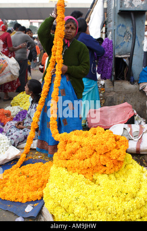 Eine Frau verkauft Blumen auf einem Straßenmarkt in Bangalore, einem der am schnellsten wachsenden Städte in Indien. Stockfoto