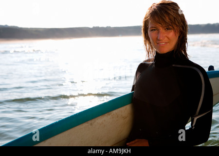 Frau mit einem Surfbrett stehend. Stockfoto