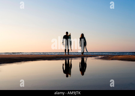 Zu zweit stehen am Strand mit Surfbrettern. Stockfoto