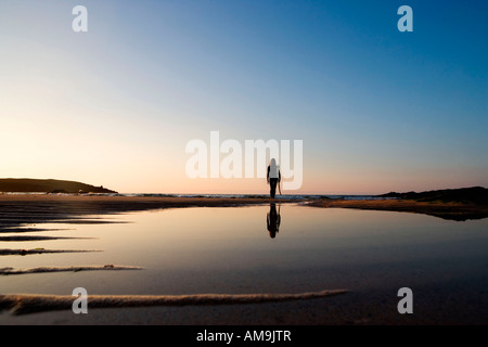 Frau am Strand mit Surfbrett stehend. Stockfoto