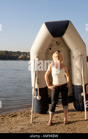 Frau stehend an einem Strand mit einem Floß und Rudern Lächeln auf den Lippen. Stockfoto