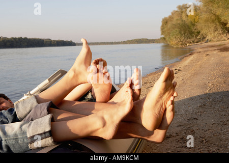 Vier Personen Beine hängen über den Rand eines Bündels. Stockfoto