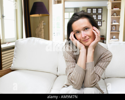 Frau sitzt auf dem Sofa im Wohnzimmer. Stockfoto