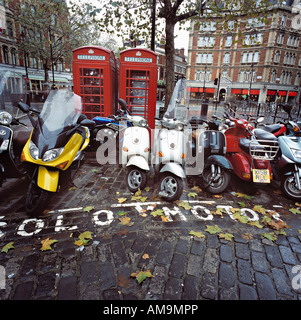Geparkten Motorräder und Roller von Telefonzellen in London. Stockfoto