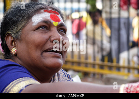 Das Gesicht von einer Blumenverkäuferin sitzen in der Nähe der Stadtmarkt in Bangalore, wie bei einem Kunden (aus dem Rahmen schaut). Stockfoto