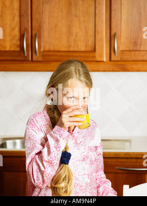 Junge Mädchen in der Küche Orangensaft trinken. Stockfoto