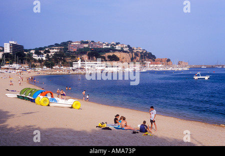 Boote und Menschen am Strand von Sant Feliu de Guixols an der Costa Brava in Spanien Stockfoto