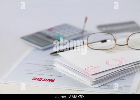 Stapel Umschläge mit Stift, Taschenrechner, Gläser und Kreditkarte Stockfoto