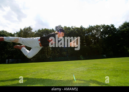 Ein Baseball-Spieler tauchen, um den Ball zu fangen Stockfoto