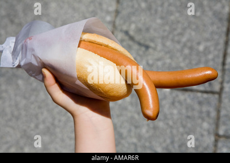 Detail eines Kindes halten Würstchen im Brötchen Stockfoto