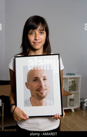Eine Frau hält eine gerahmte Fotografie Stockfoto