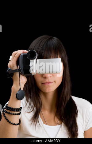 Eine junge Frau, die eine Videokamera vor ihr Gesicht halten Stockfoto