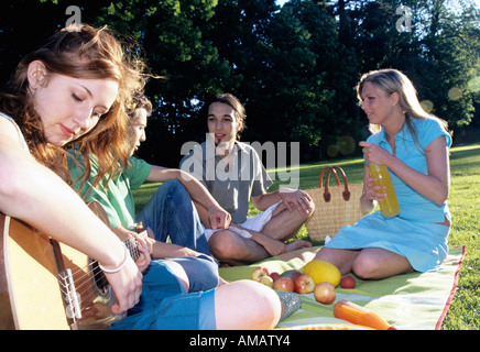 Junge Frau, die Gitarre für Freunde im Garten, Nahaufnahme Stockfoto