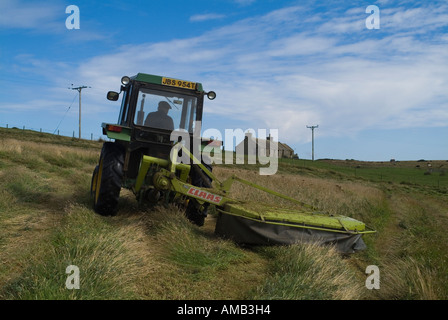 Dh ERNTE UK Traktor schneiden Grassilage für die Ernte und die Cottage Orphir Orkney Stockfoto