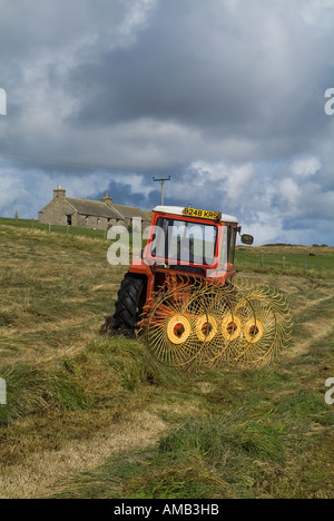 dh ERNTE UK Farm Traktor Verbreitung Silage Orkney Landwirtschaft Verbreitung Drehen Trockengras Landwirtschaft Maschine Feld Rechen Heu Schneiden schottland Stockfoto