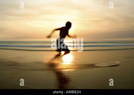 Skimboarding Mann vor Sonnenuntergang Stockfoto