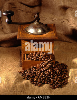 Alte Kaffeemühle mit Kaffeebohnen. Stockfoto
