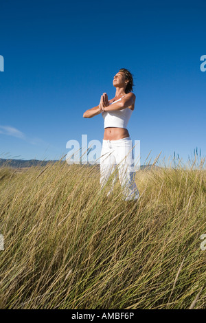 junge Frau in der spirituellen Praxis mit Händen in betender Stellung Stockfoto