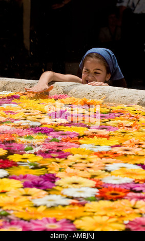 Einem Augenzwinkern und einem Splash A jungen Mädchen schlägt ihre Hand in einem Brunnen voller Blumen während des jährlichen l'infiorata oder Blume-festival Stockfoto