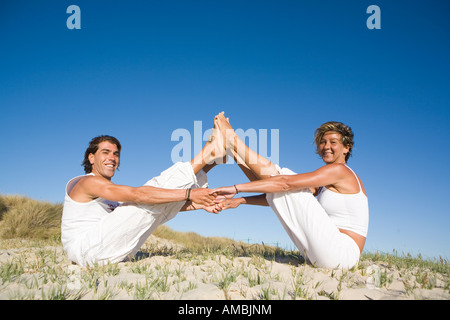 Mann und Frau zusammen mit Füßen dehnen und Hand in Hand Stockfoto