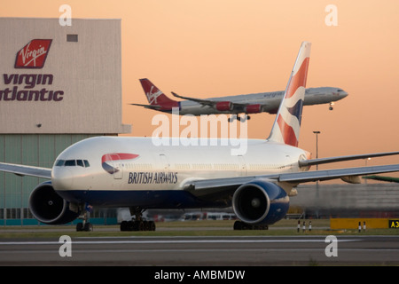 British Airways Boeing 777 des Rollens bei Abreise während Virgin Atlantic Airbus A340 Landung im Hintergrund der Flughafen Heathrow UK Stockfoto