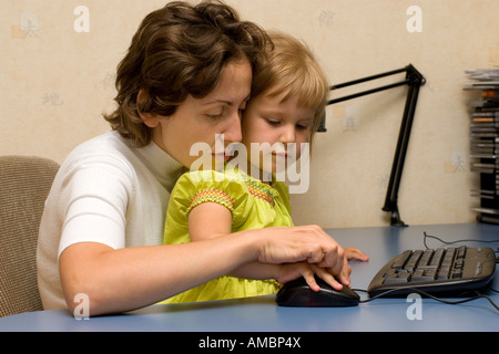 Eine Mutter, die helfen, ihre Tochter zu einer Computer-Maus Stockfoto