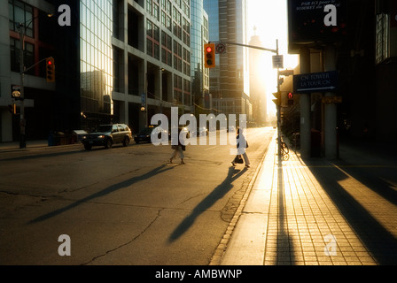 Zwei Frauen in der frühen Morgensonne auf dem Weg zur Arbeit im Finanzdistrikt Torontos Silhouette Stockfoto