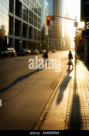 Zwei Frauen in der frühen Morgensonne auf dem Weg zur Arbeit im Finanzdistrikt Torontos Silhouette Stockfoto