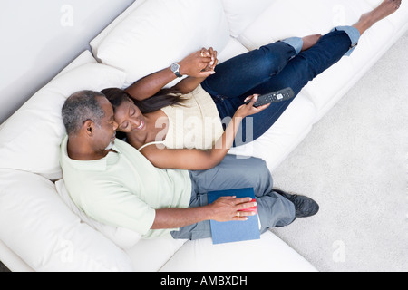 Vogelperspektive Blick auf ein paar mittleren Alters romancing auf einer couch Stockfoto