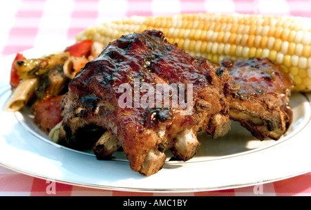 Baby Back ribs, Maiskolben, und ein Medley aus frischem Gemüse sorgen für einen perfekten Urlaub-Grill Stockfoto