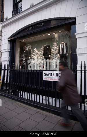 Fußgängerspaziergänge vorbei am Gieves & Hawkes Geschäft in Savile Row, london. uk. Stockfoto