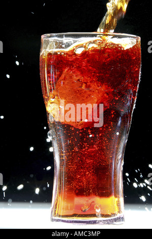 Cola ist in ein Glas mit Eis gießen. Stockfoto