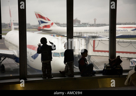 Kinder Verabschieden abfliegenden Flugzeuge am Flughafen Heathrow Stockfoto