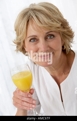 Reife Frau mit Glas Orangensaft Stockfoto