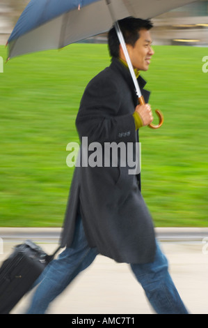 Man Walking im Freien, mit Regenschirm Stockfoto