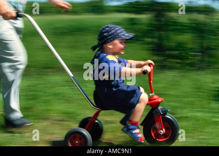 Kind auf Fahrrad geschoben Stockfoto