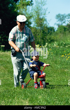 Kind auf Fahrrad geschoben Stockfoto