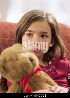 Mädchen auf Sofa mit Teddybär Stockfoto