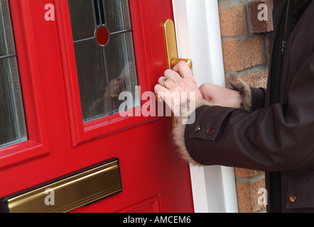 Frau, die die Haustüre aufmacht, norfolk, england Stockfoto